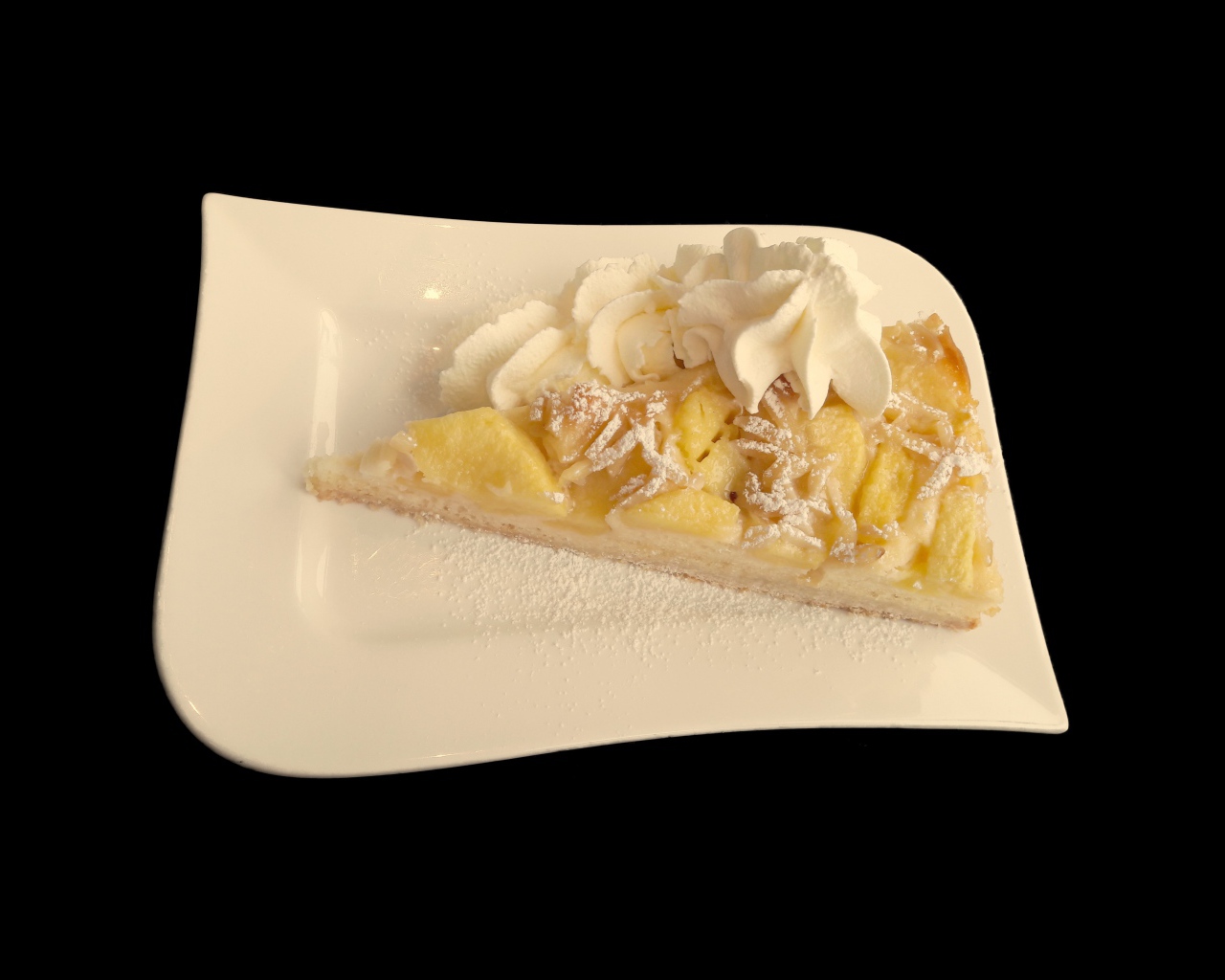 Кусок пирога с фруктами в белой тарелке на черном фоне