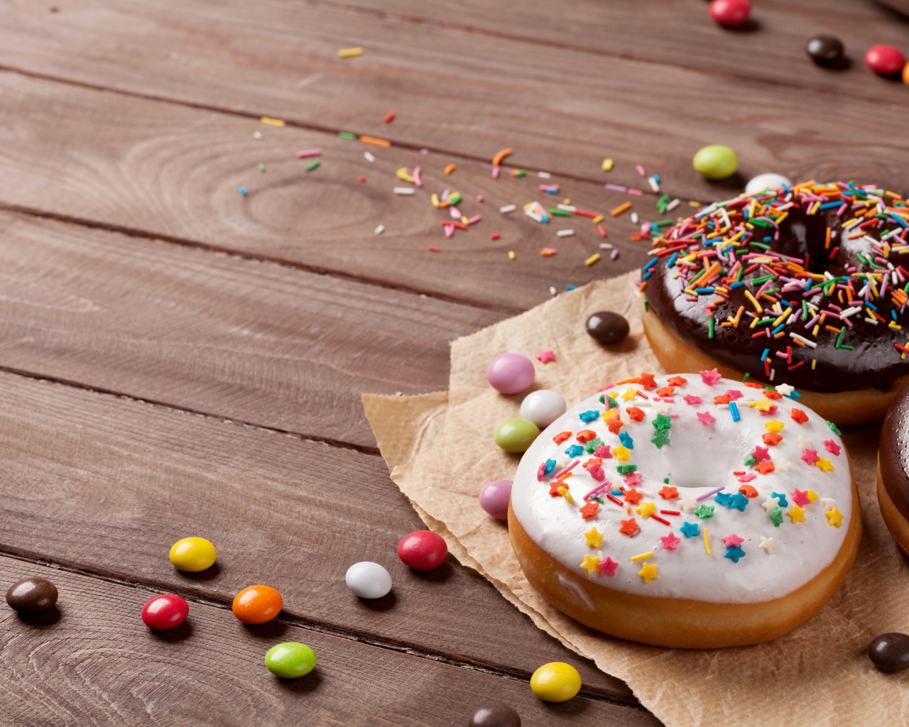 Сладкие пончики с глазурью на столе с конфетами