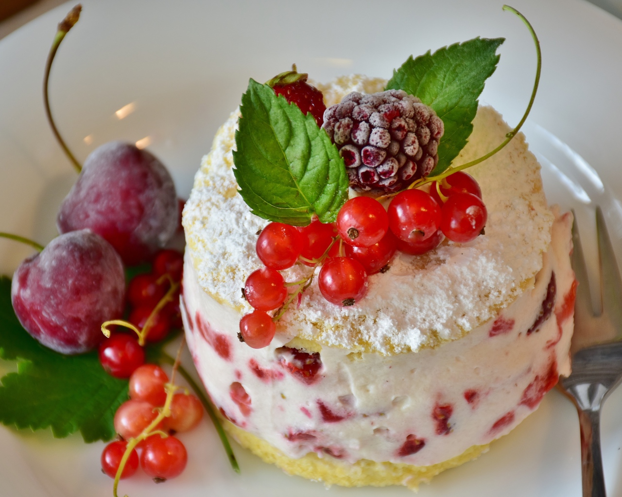 Пирожное со взбитыми сливками украшено ягодами