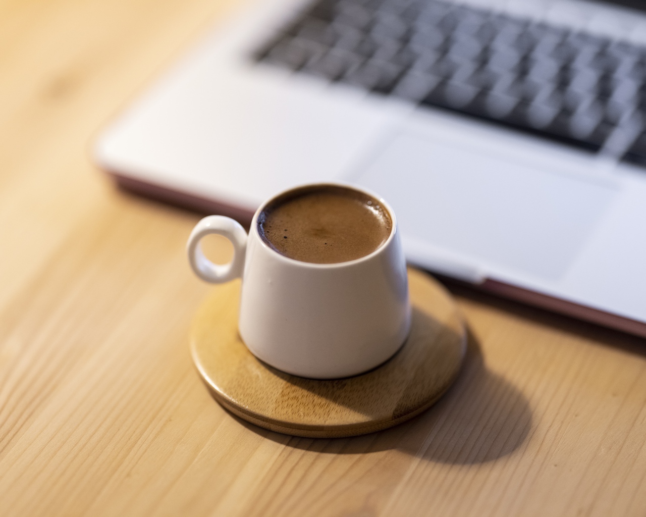 Чашка кофе стоит у ноутбука 