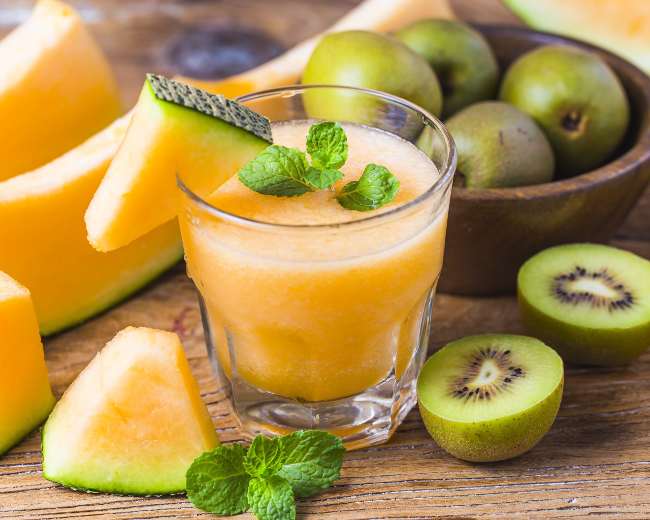 Стакан сока на столе с киви и дыней