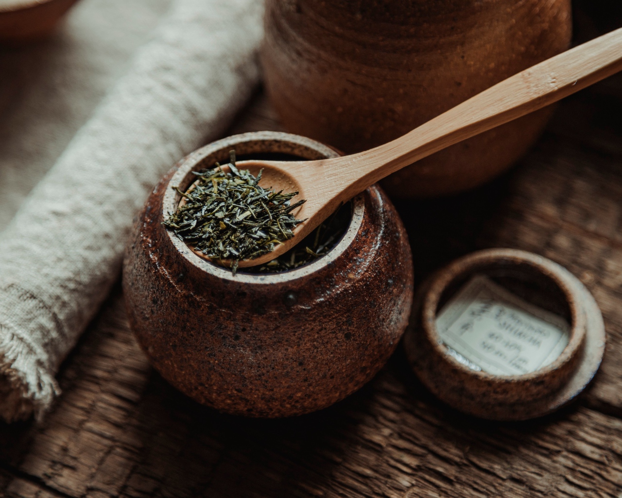 Глиняный горшочек с листовым чаем и деревянной ложкой 