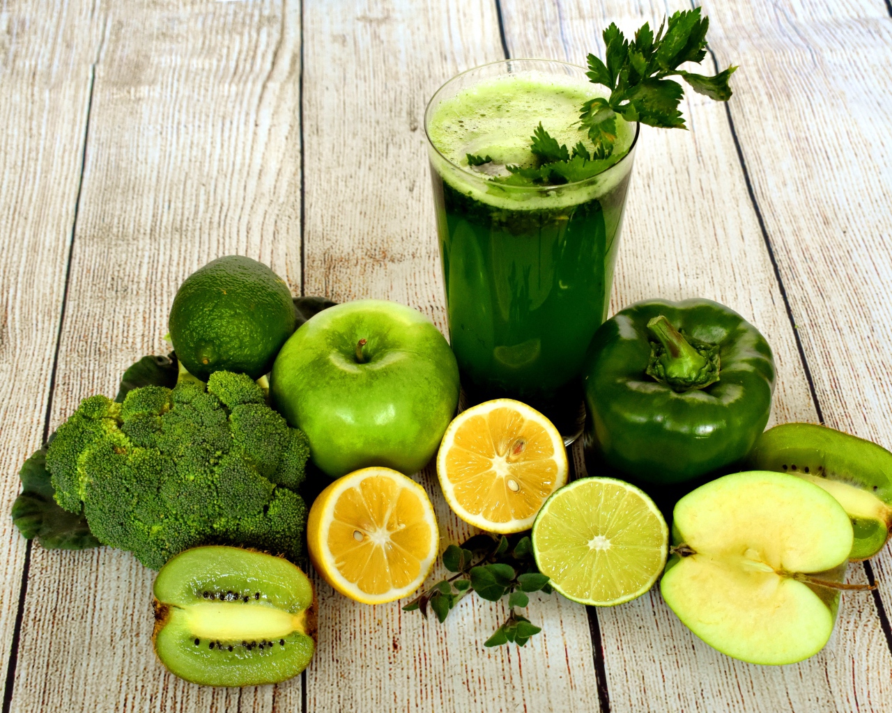 Зеленый свежий смузи на столе с овощами и фруктами 