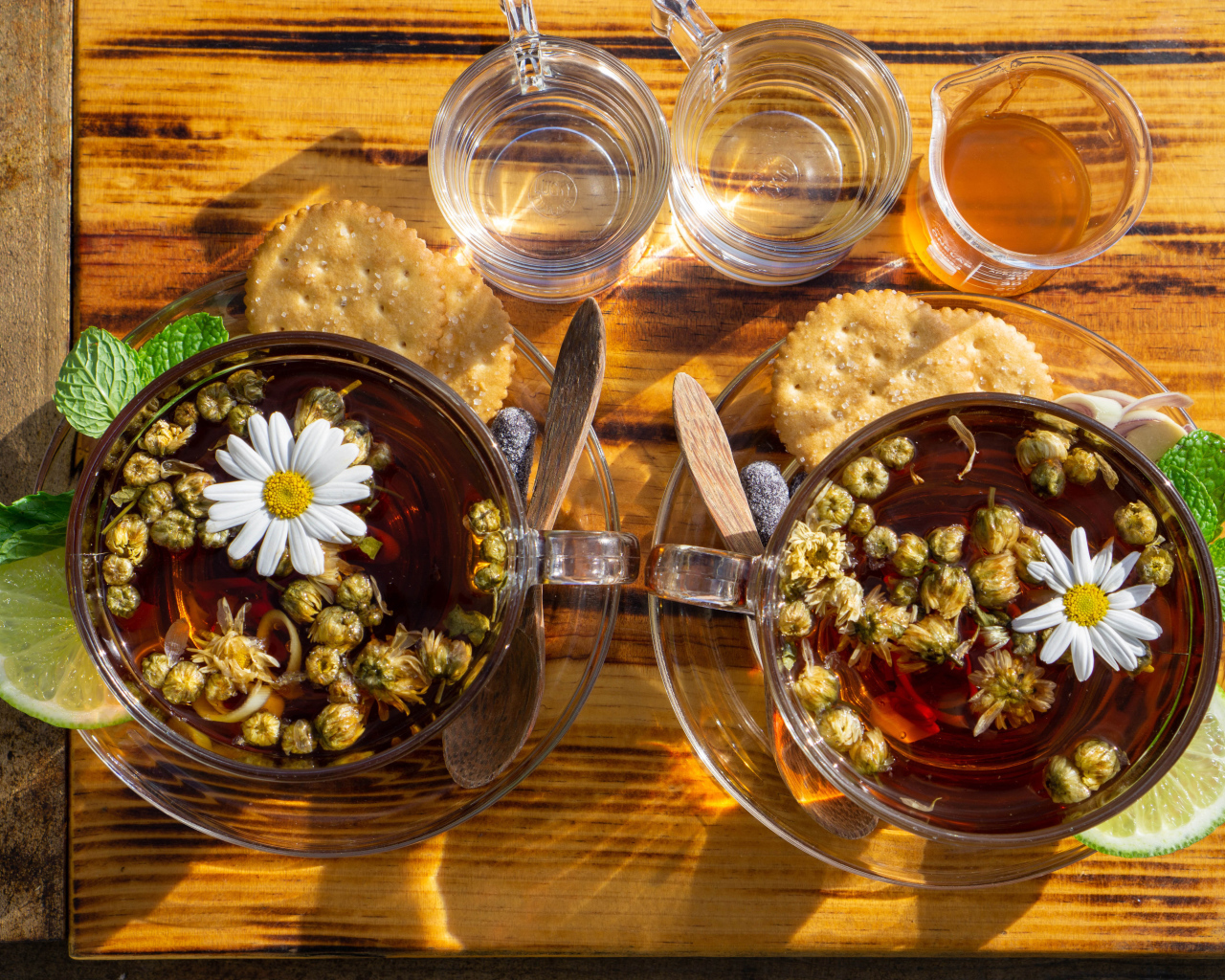 Две чашки чая с ромашкой на столе с медом