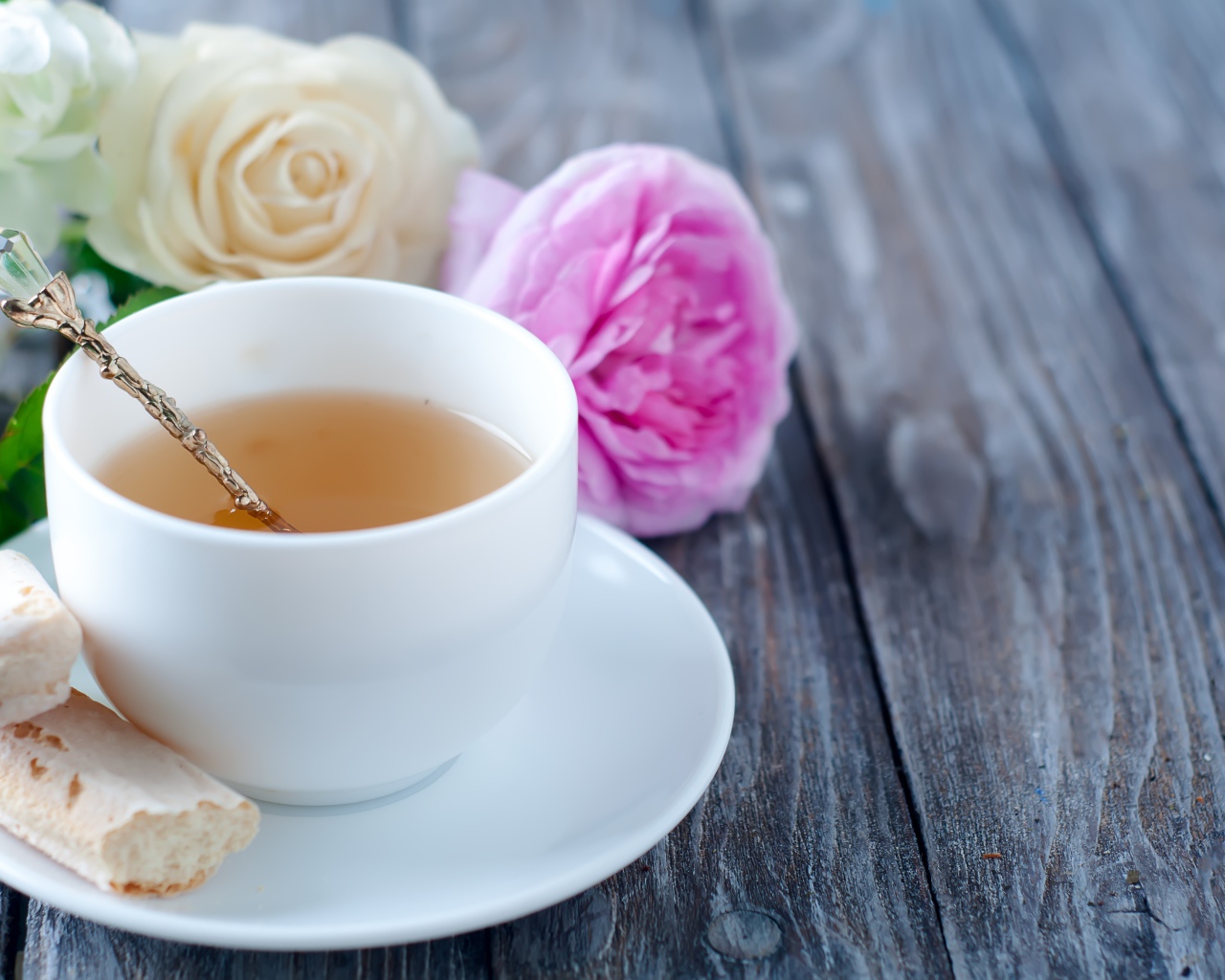 Белая чашка чая на деревянном  столе с розами