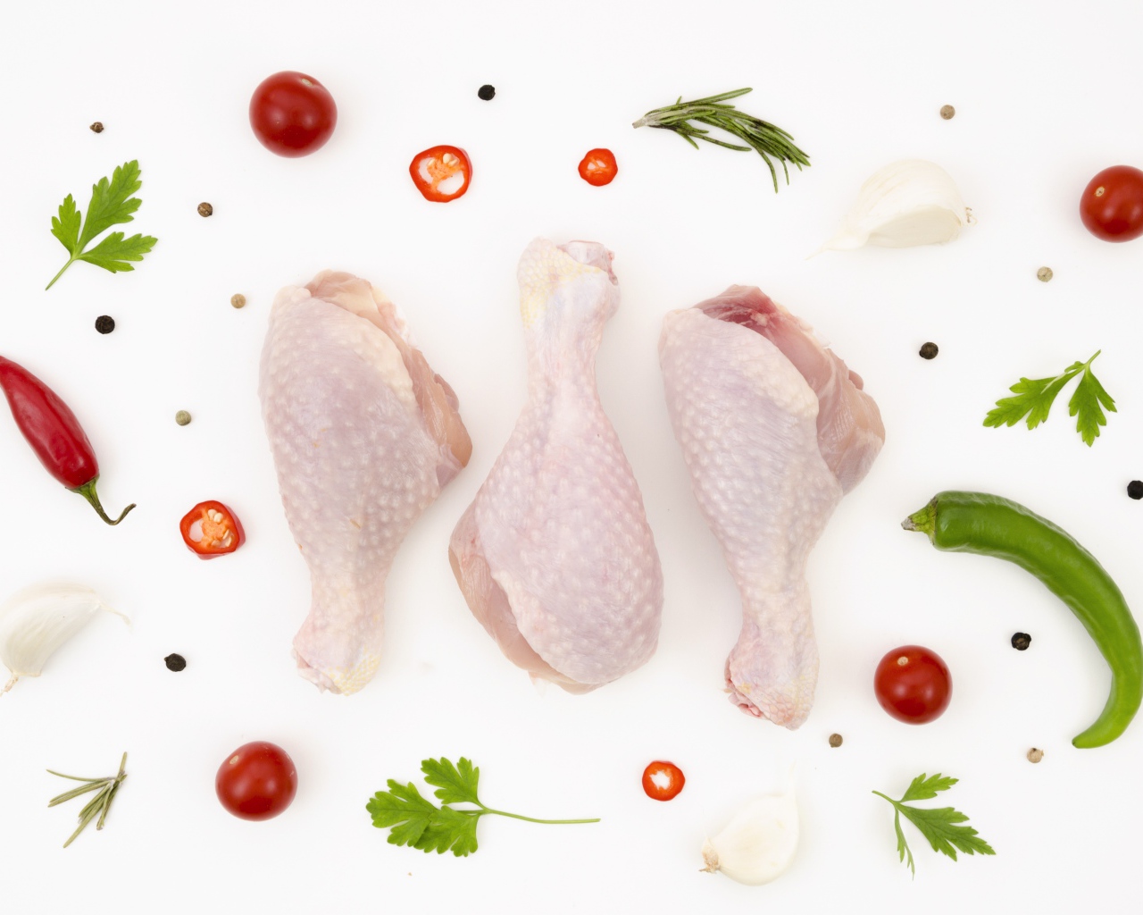 Свежие куриные бедра с перцем и помидорами на белом фоне 
