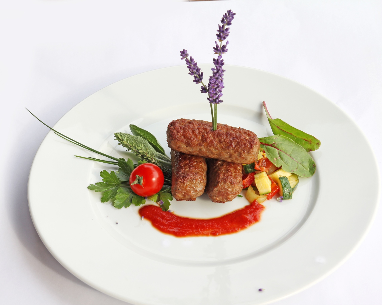 Мясные палочки на тарелке с зеленью и соусом