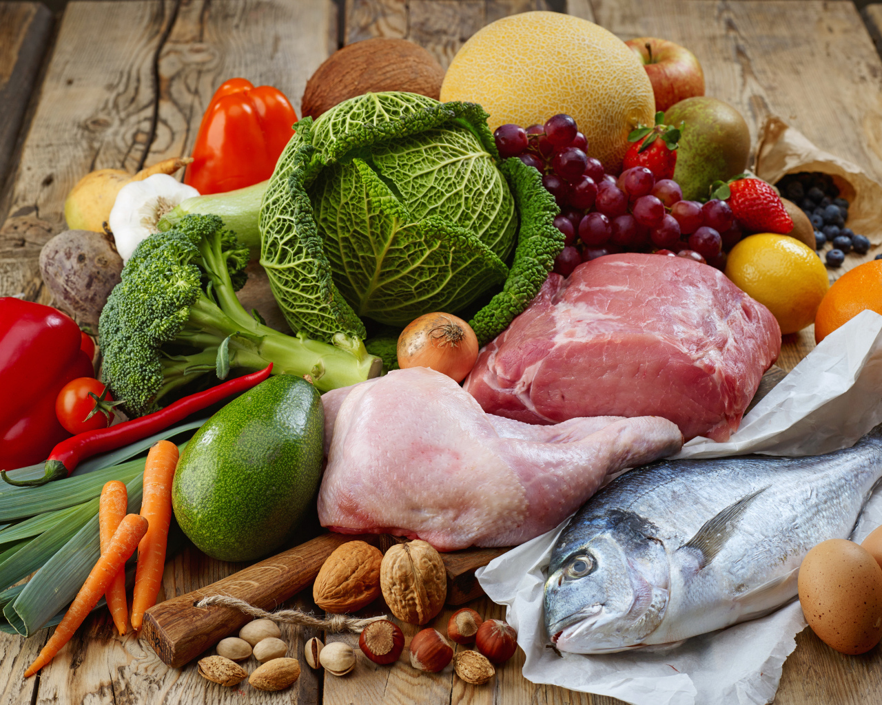 Мясо с рыбой на столе с овощами и фруктами 