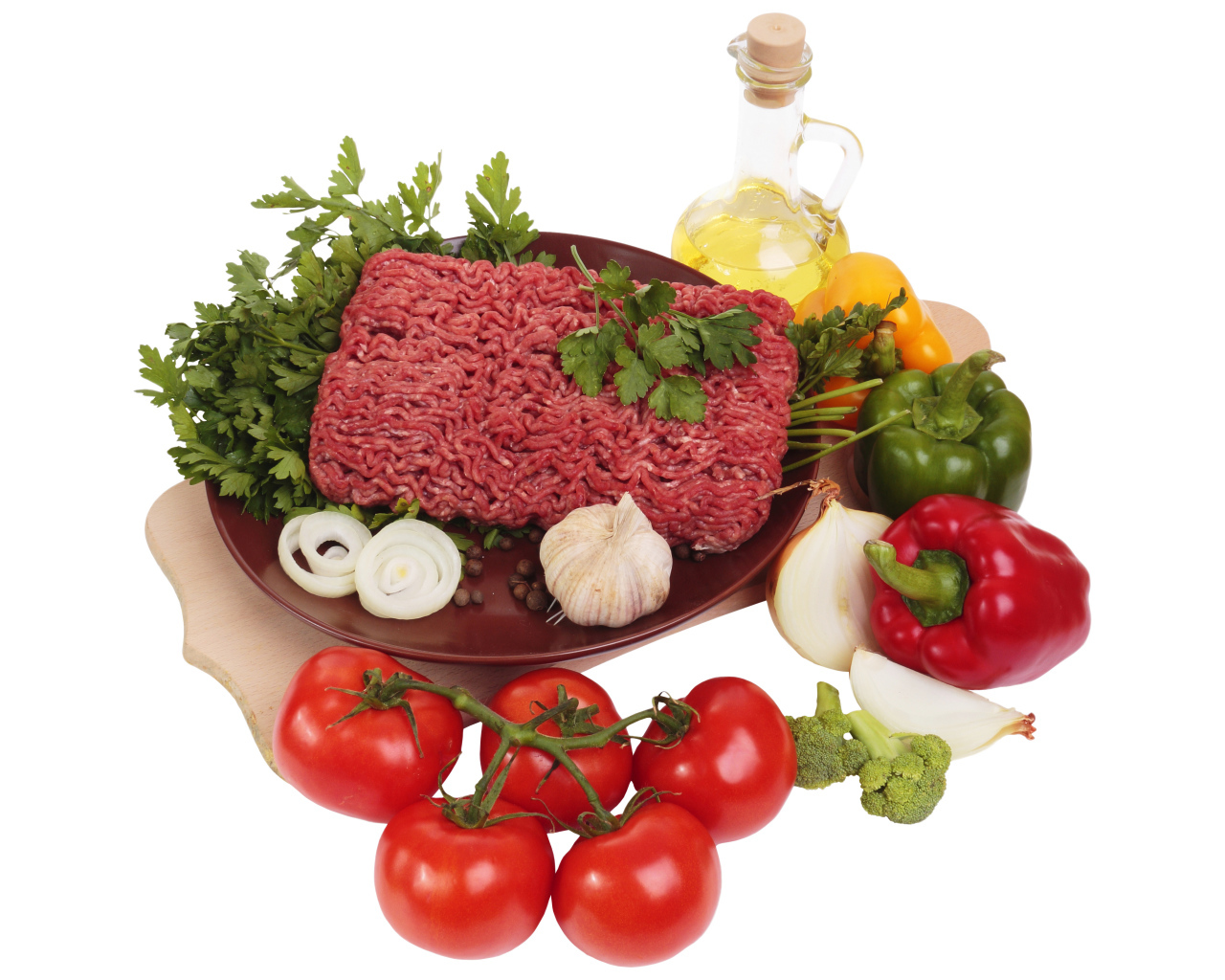 Minced meat on a white plate with vegetables and herbs