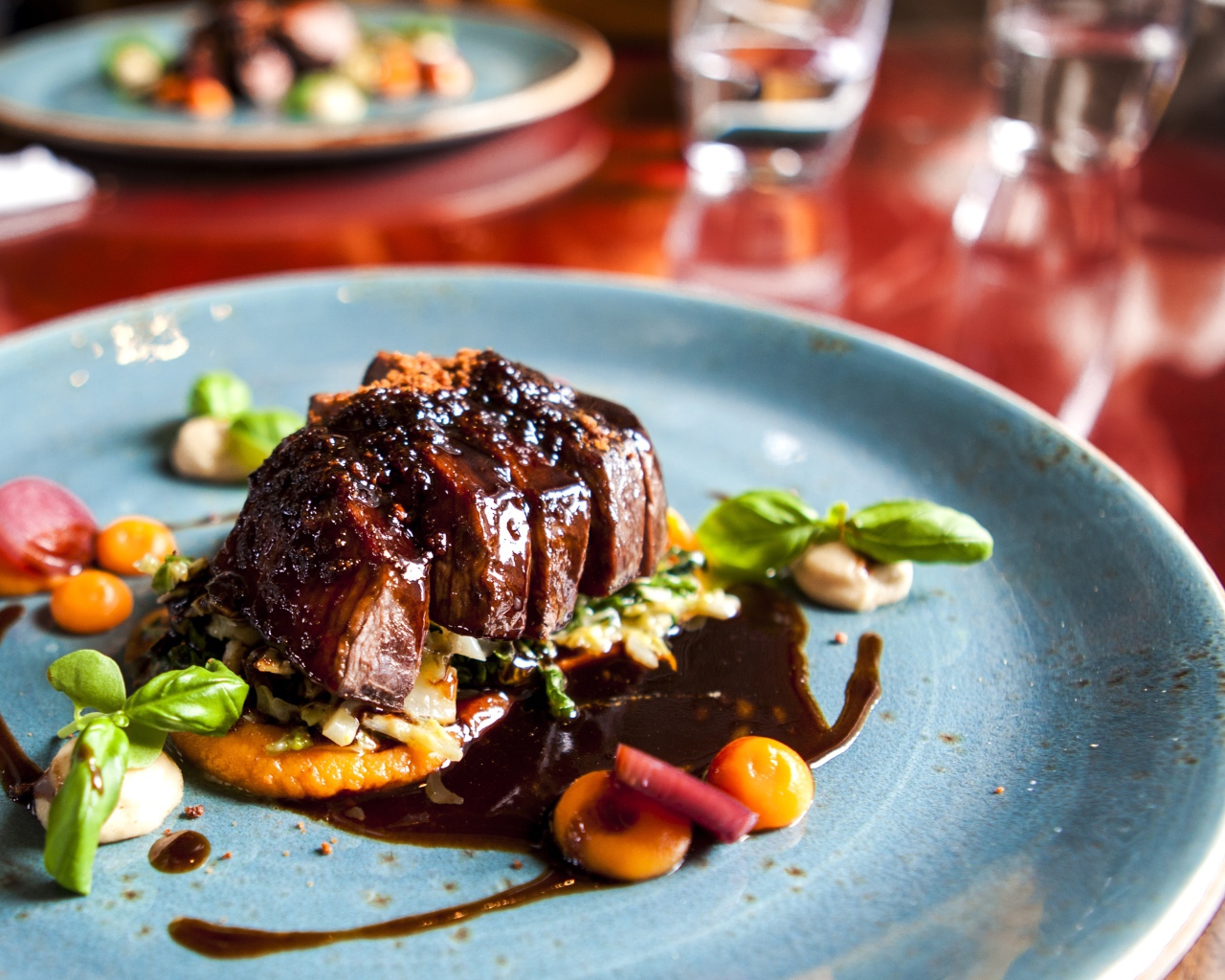 Кусок мяса с соусом на тарелке в ресторане