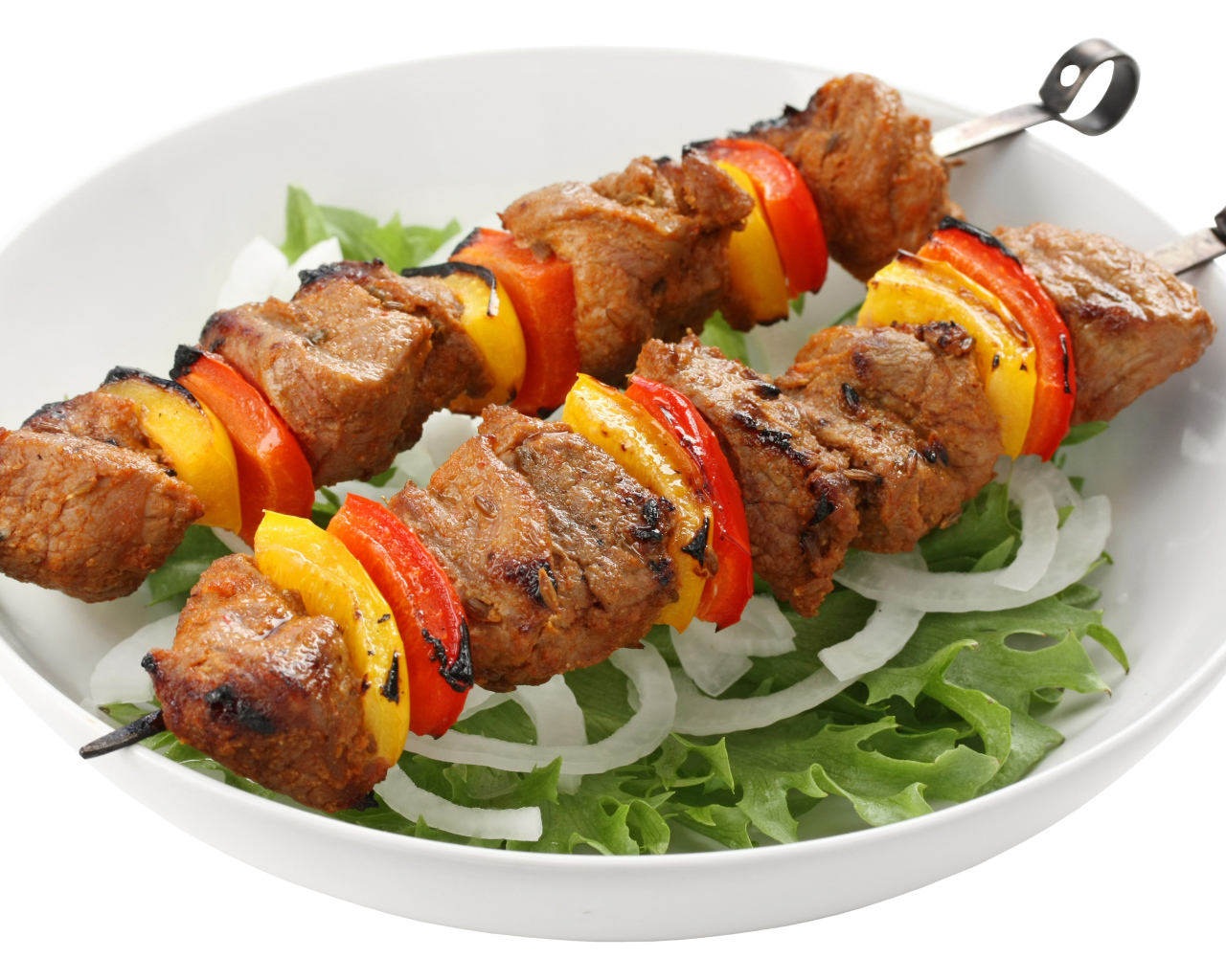 Шашлык с болгарским перцем на тарелке с листьями салата