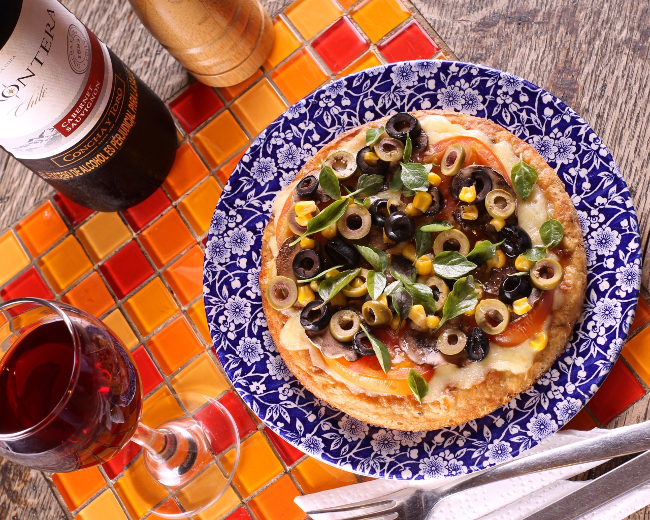 Итальянская пицца с оливками на столе с вином