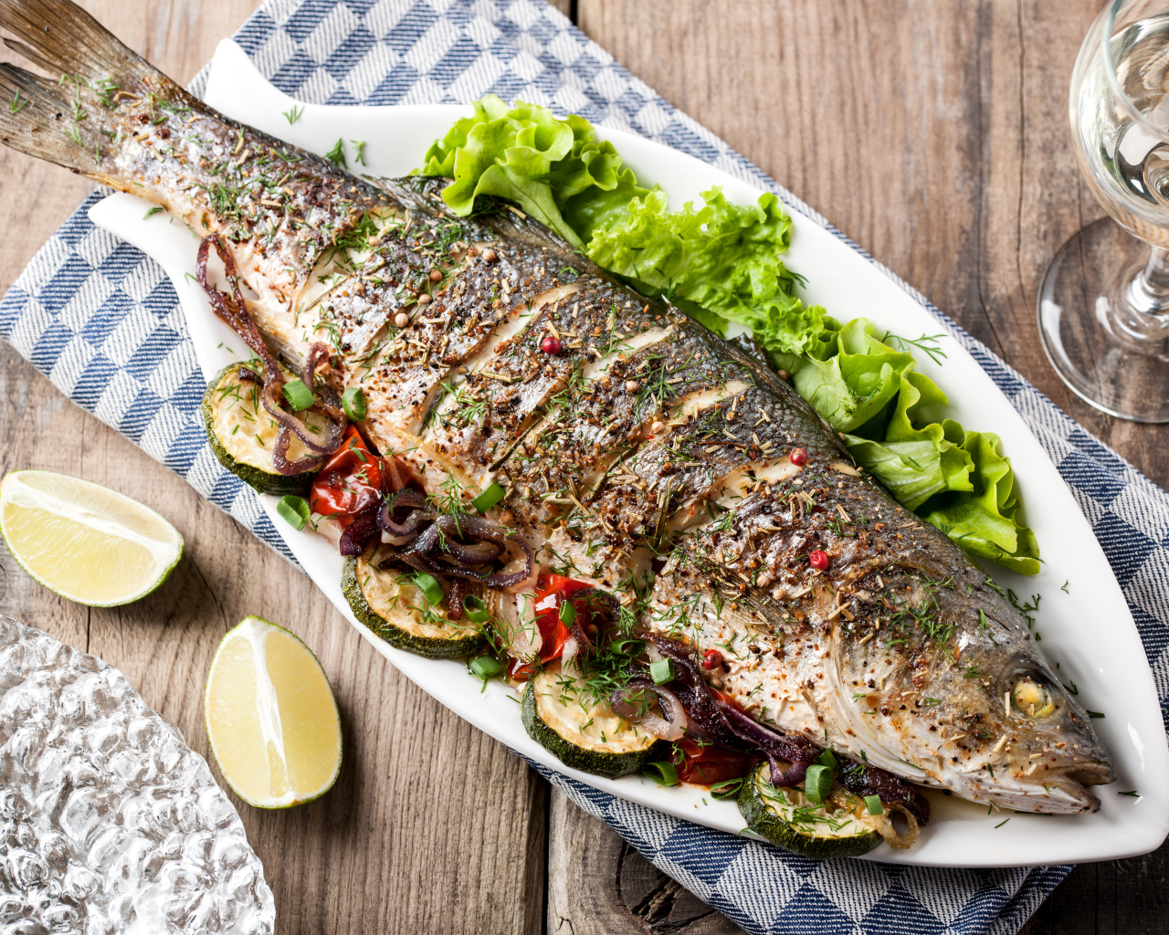 Большая запеченная рыба с кабачками и листьями салата