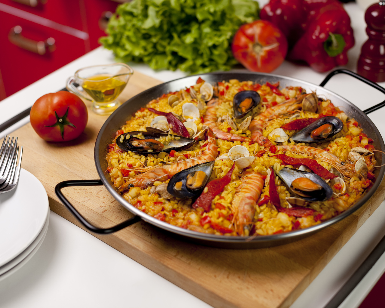 Плов с морепродуктами на столе с овощами