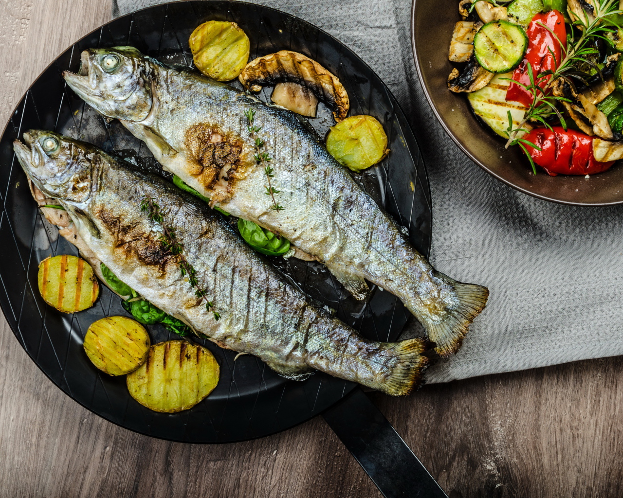 Две рыбины на сковороде с овощами