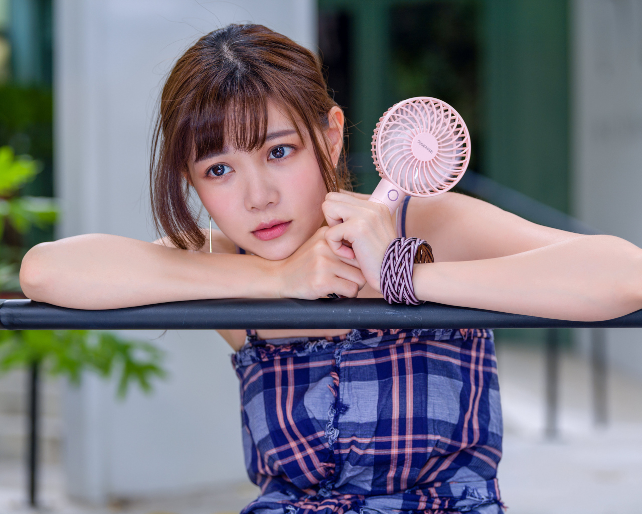 Девушка азиатка с вентилятором в руке 