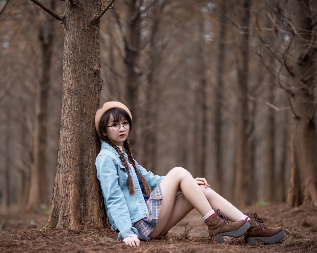 Девушка азиатка школьница сидит под деревом