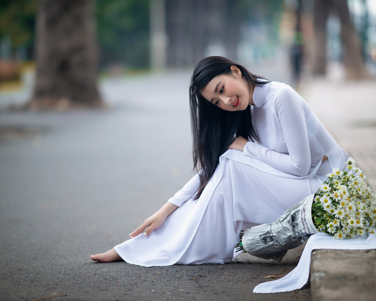 Красивая девушка азиатка в белом платье с букетом ромашек