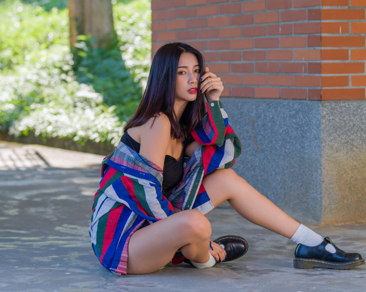 Красивая азиатка в рубашке у стены