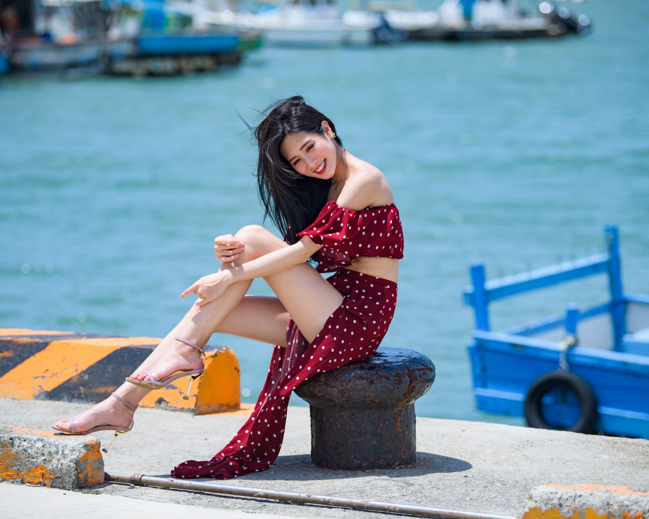 Красивая девушка азиатка в платье в горох у моря