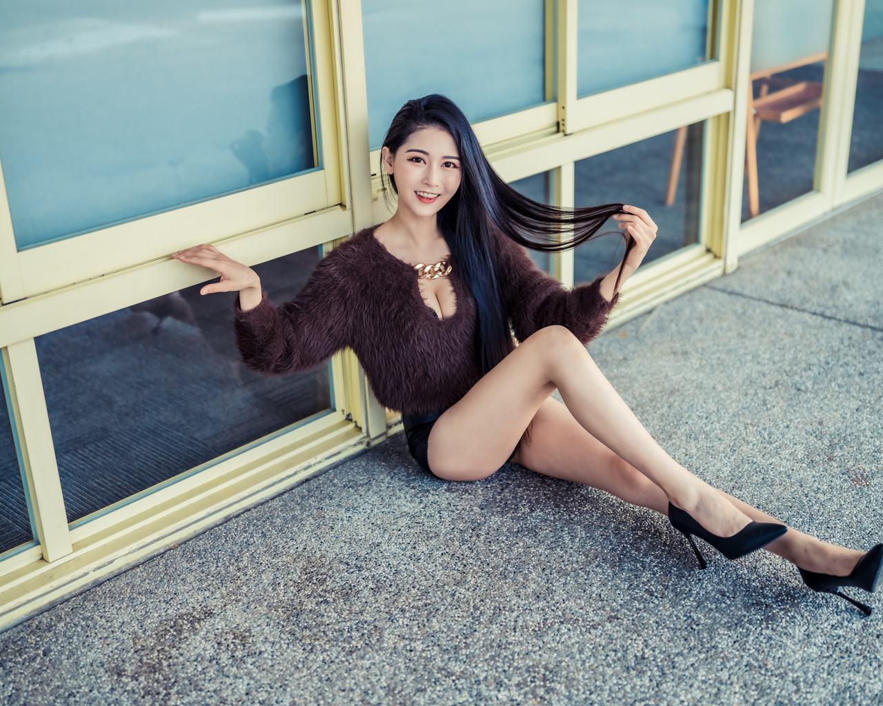 Красивая девушка азиатка в черных туфлях на земле 