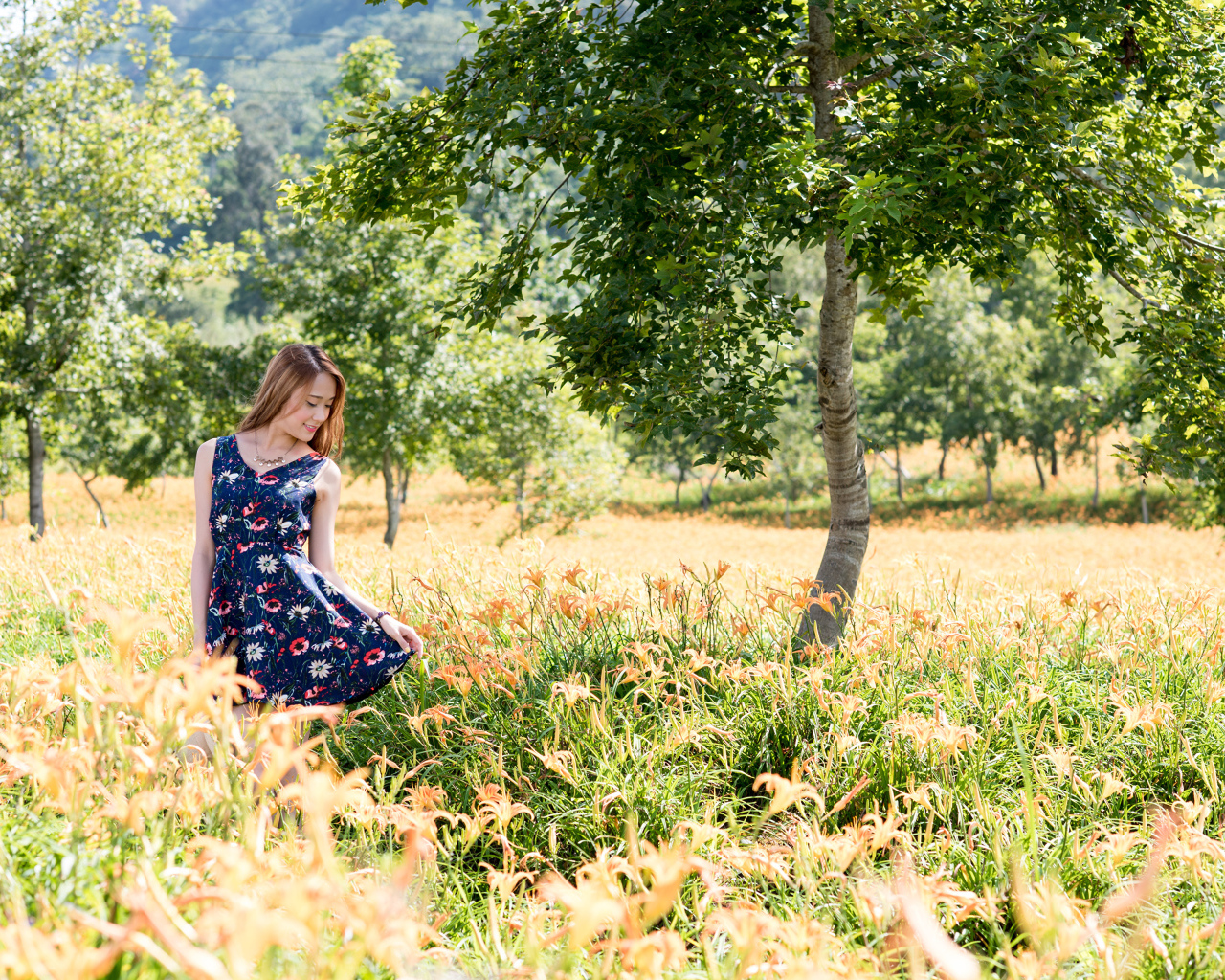 Красивая азиатка гуляет по высокой траве