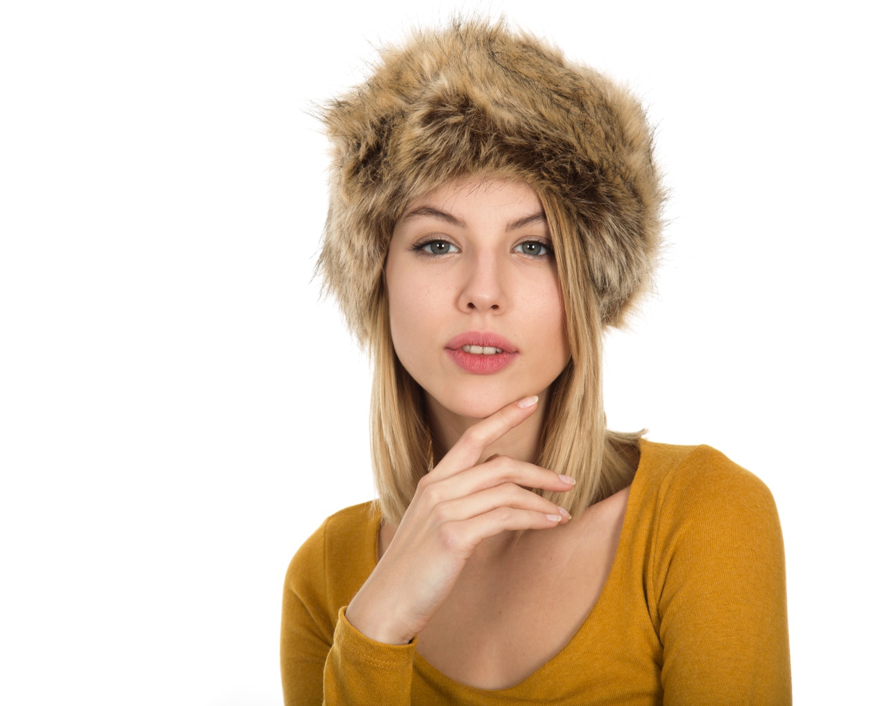 Красивая девушка блондинка в меховой шапке на белом фоне 