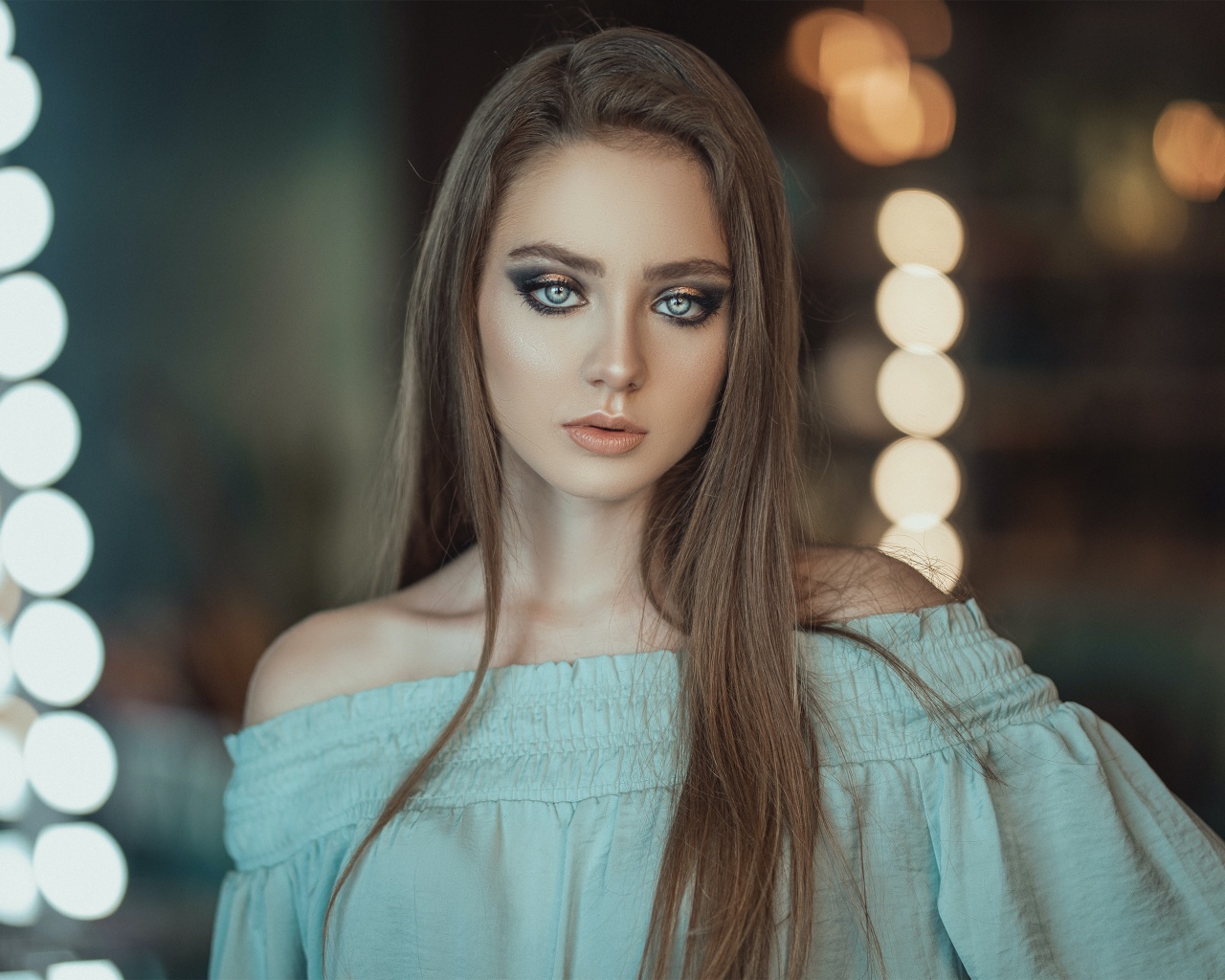 Красивая голубоглазая девушка в платье у зеркала 