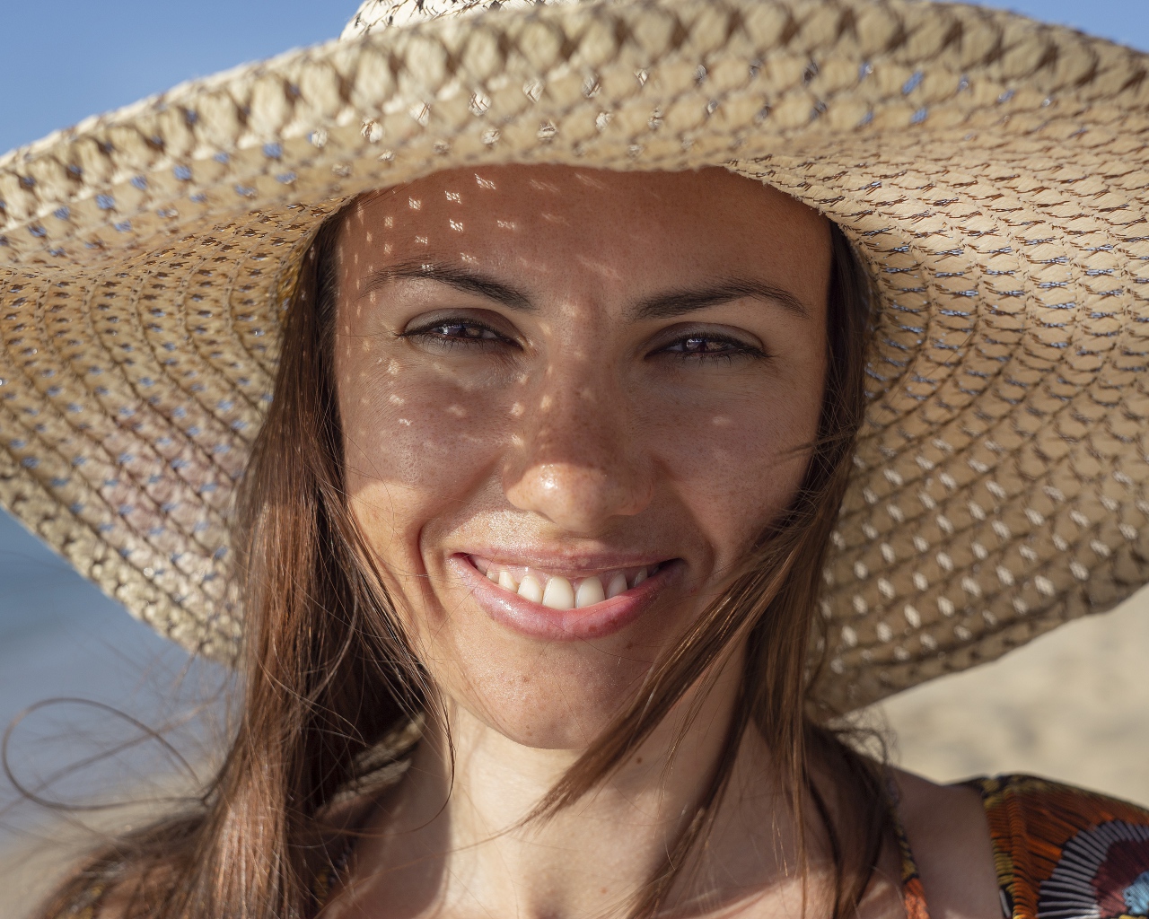 Красивая кареглазая девушка в большой соломенной шляпе 