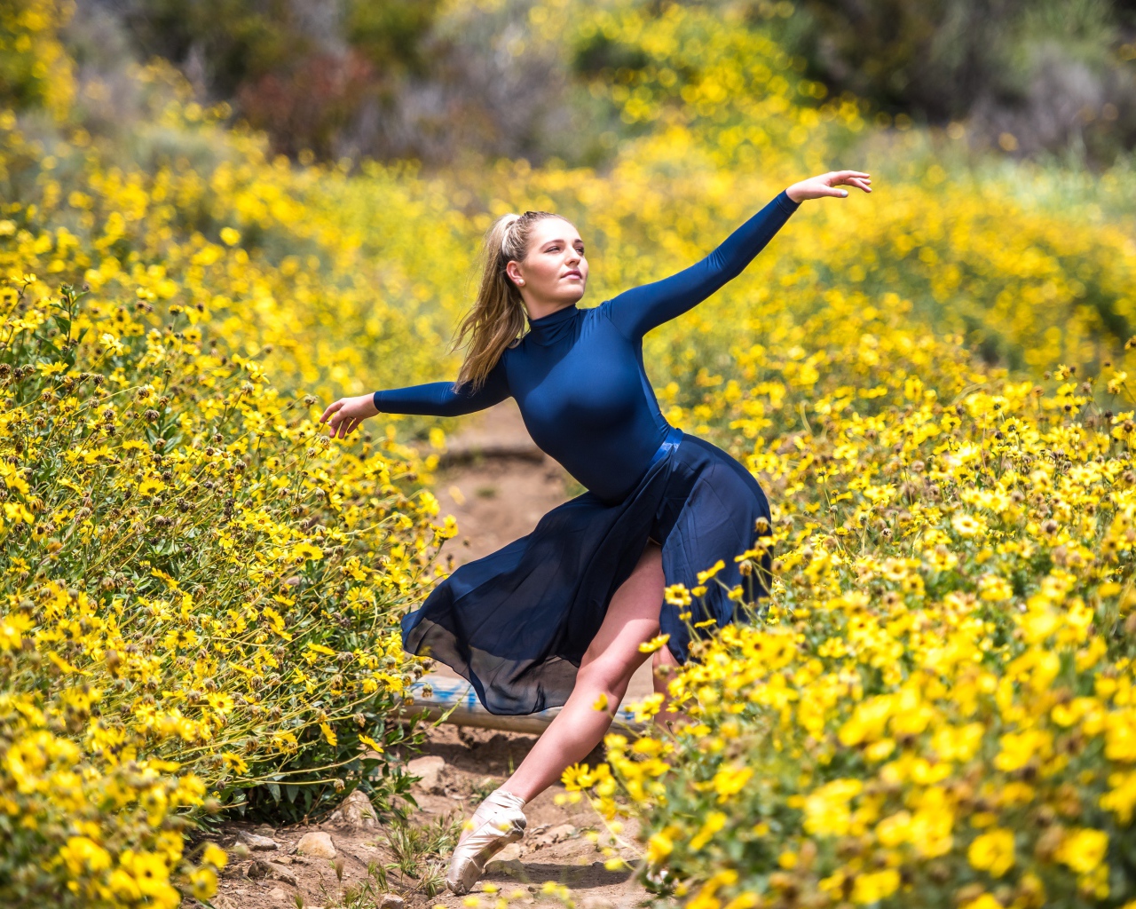 Красивая девушка балерина на поле с желтыми цветами