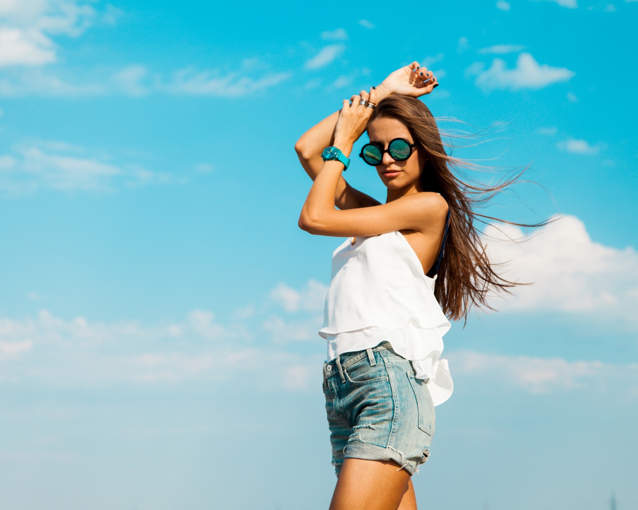 Красивая девушка в шортах на фоне неба
