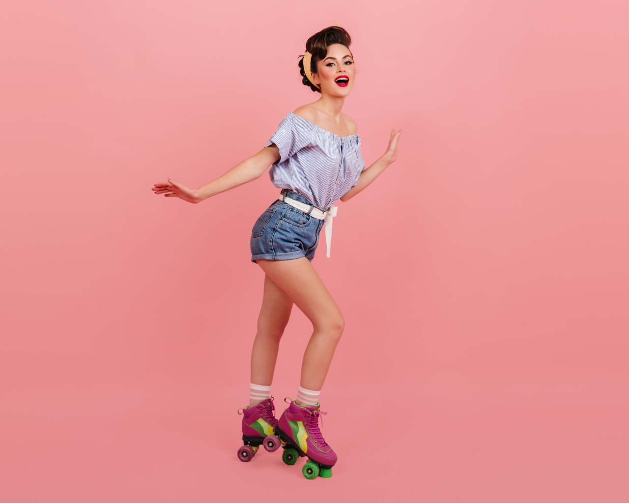 Красивая девушка на роликах на розовом фоне 