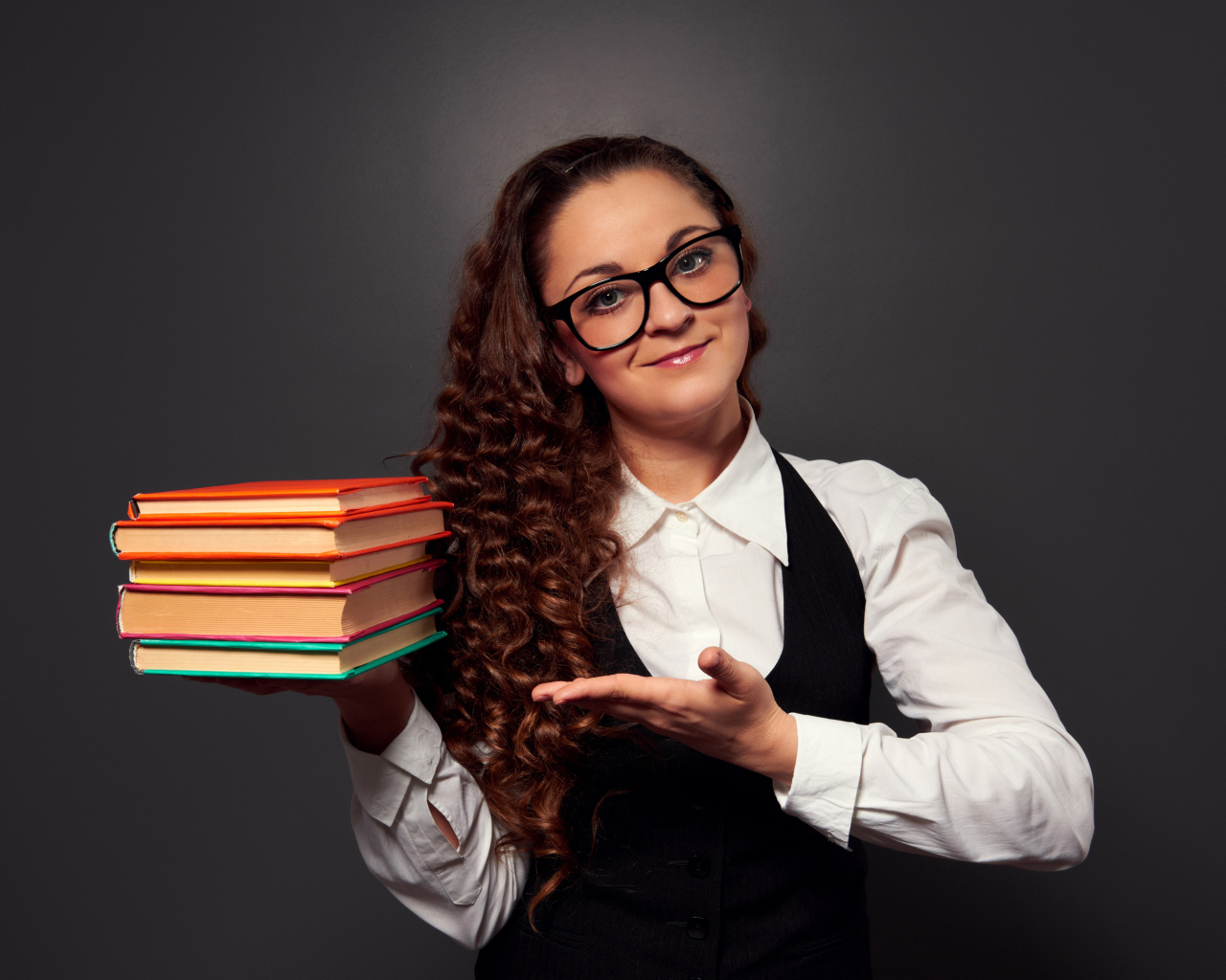 Красивая девушка учитель в очках с книгами в руке