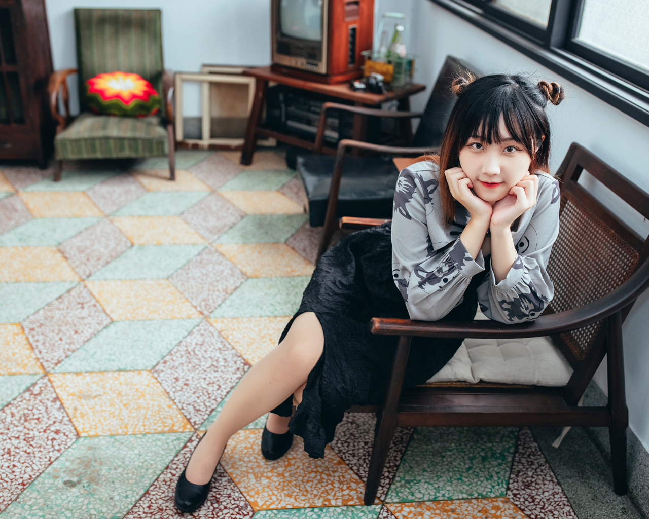 Красивая молодая азиатка сидит в кресле