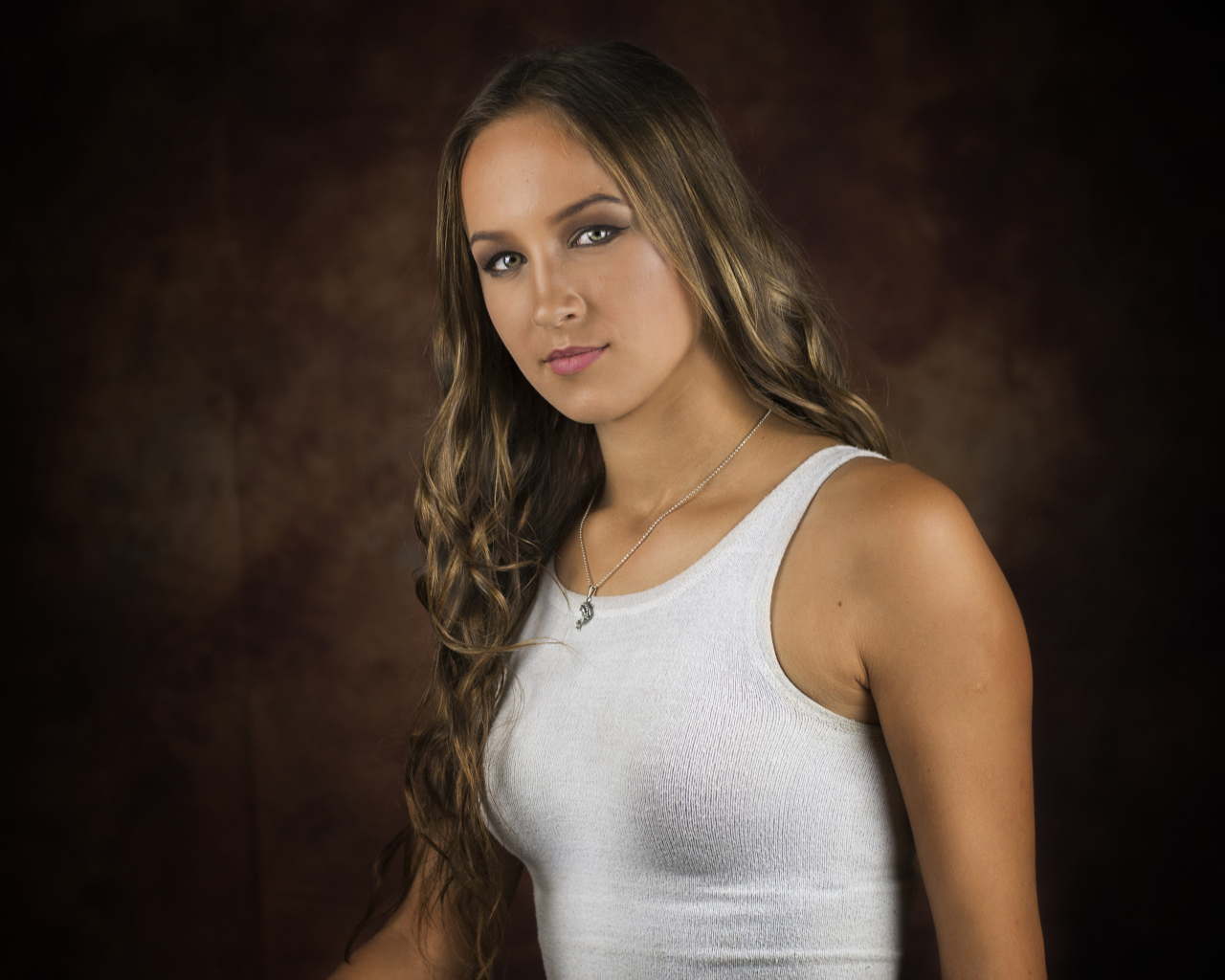 Красивая молодая девушка с длинными волосами в белой майке 