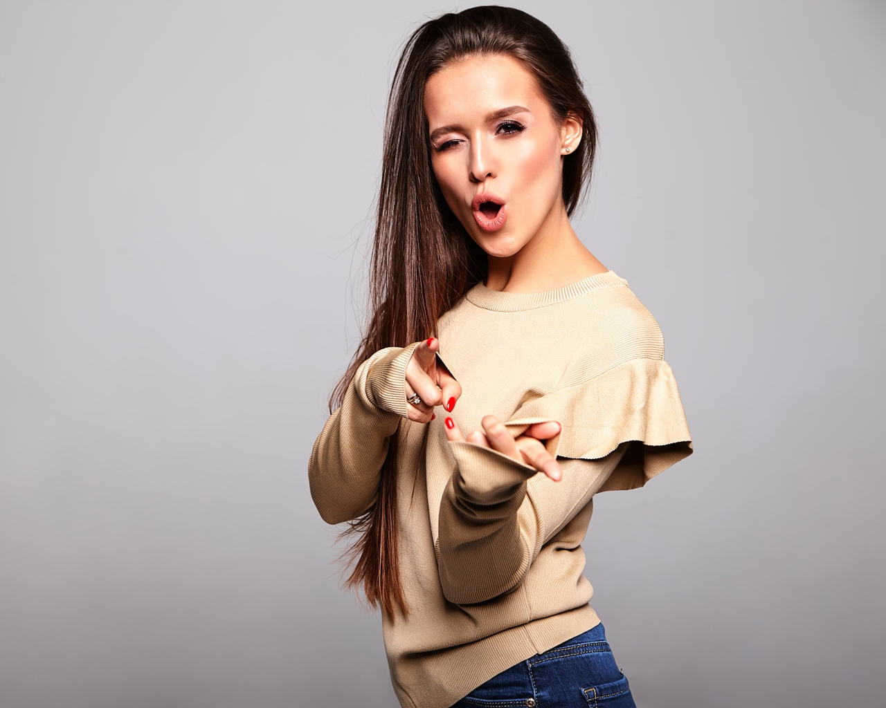 Яркая длинноволосая девушка на сером фоне 