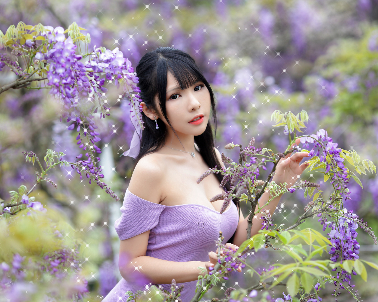 Кареглазая азиатка у куста с цветами глицинии