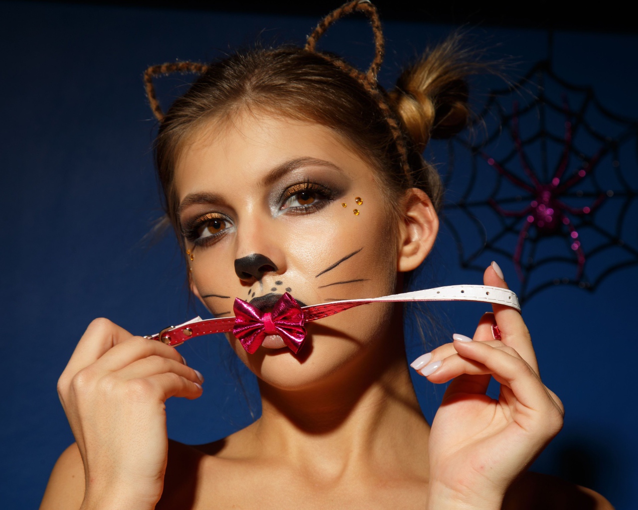 Девушка кошка с красным бантиком во рту 