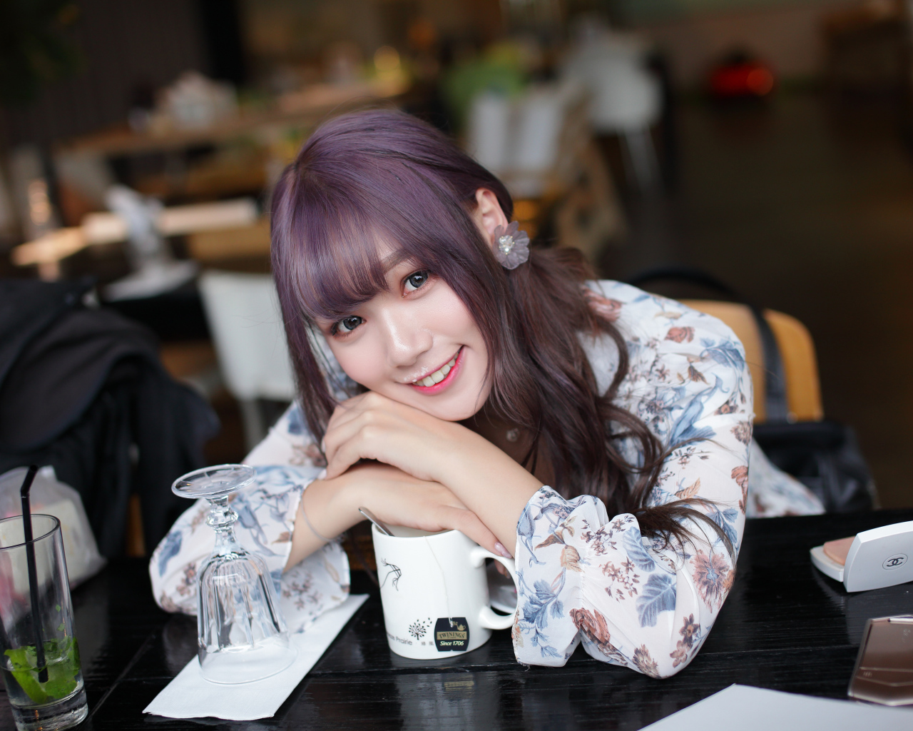 Милая девушка азиатка сидит за столиком