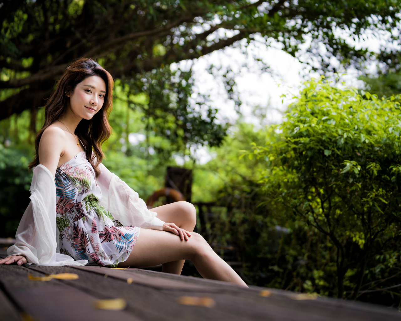 Милая девушка азиатка сидит на мосту