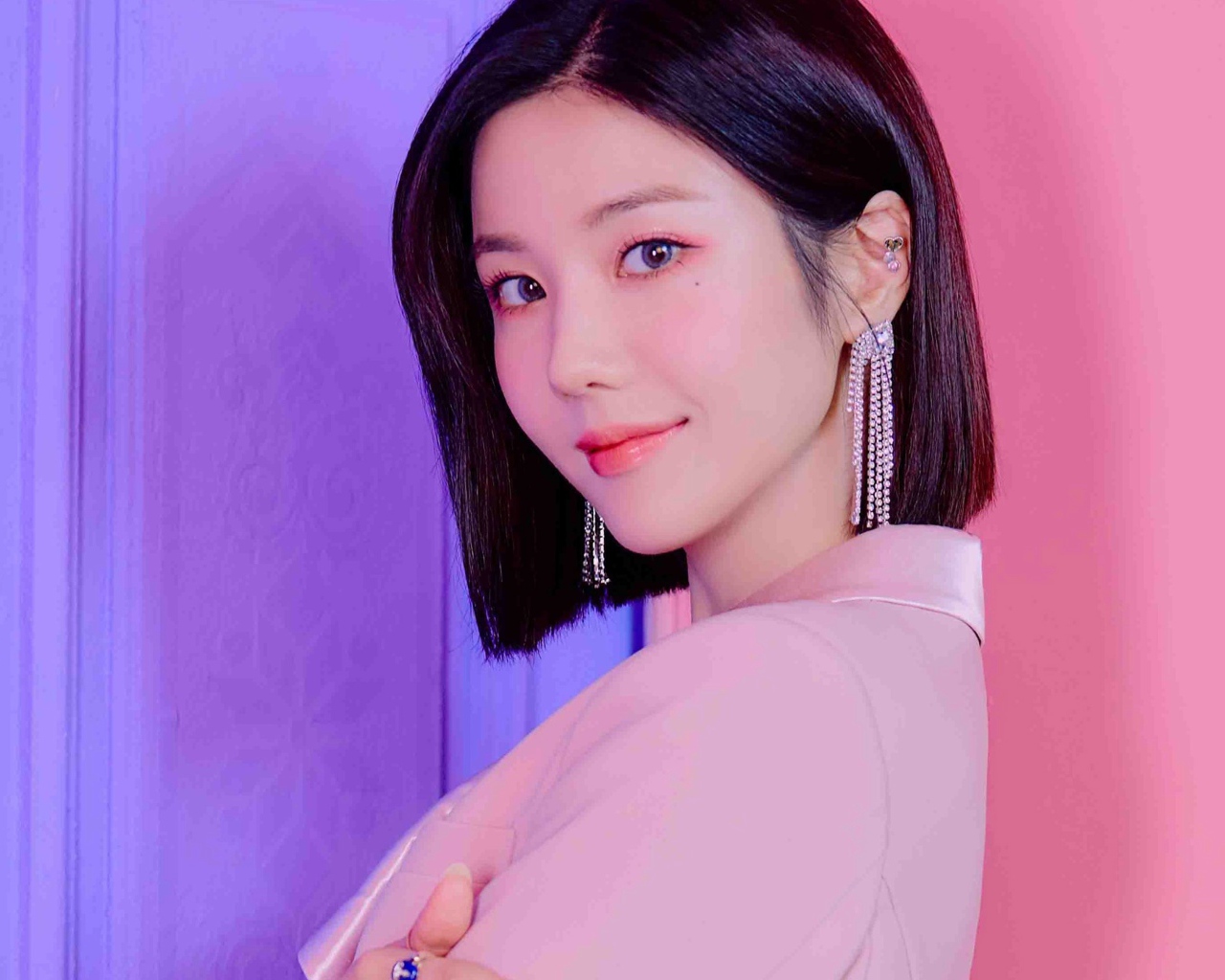 Милая девушка азиатка с короткой стрижкой на розовом фоне 