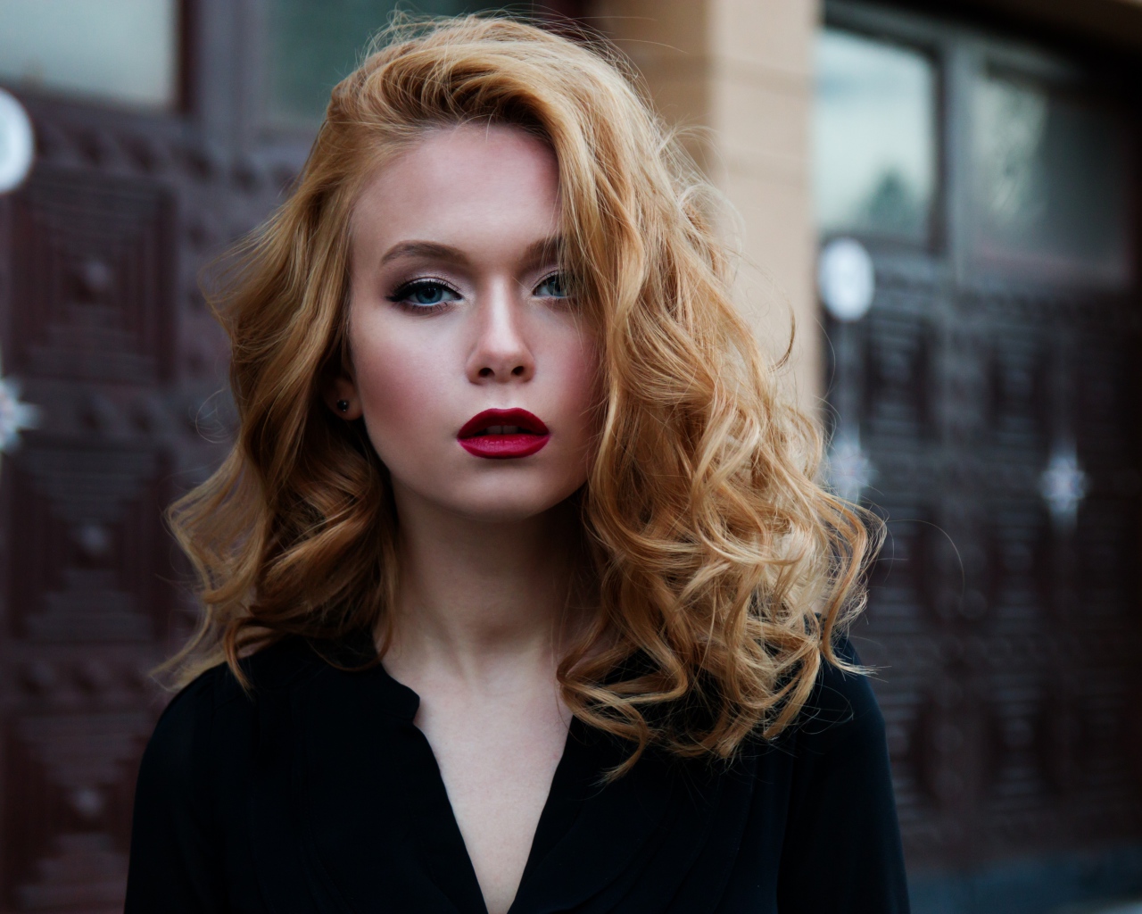 Милая блондинка с красными губами у дома