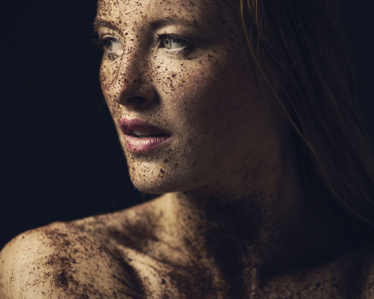 Грязная девушка в земле на черном фоне
