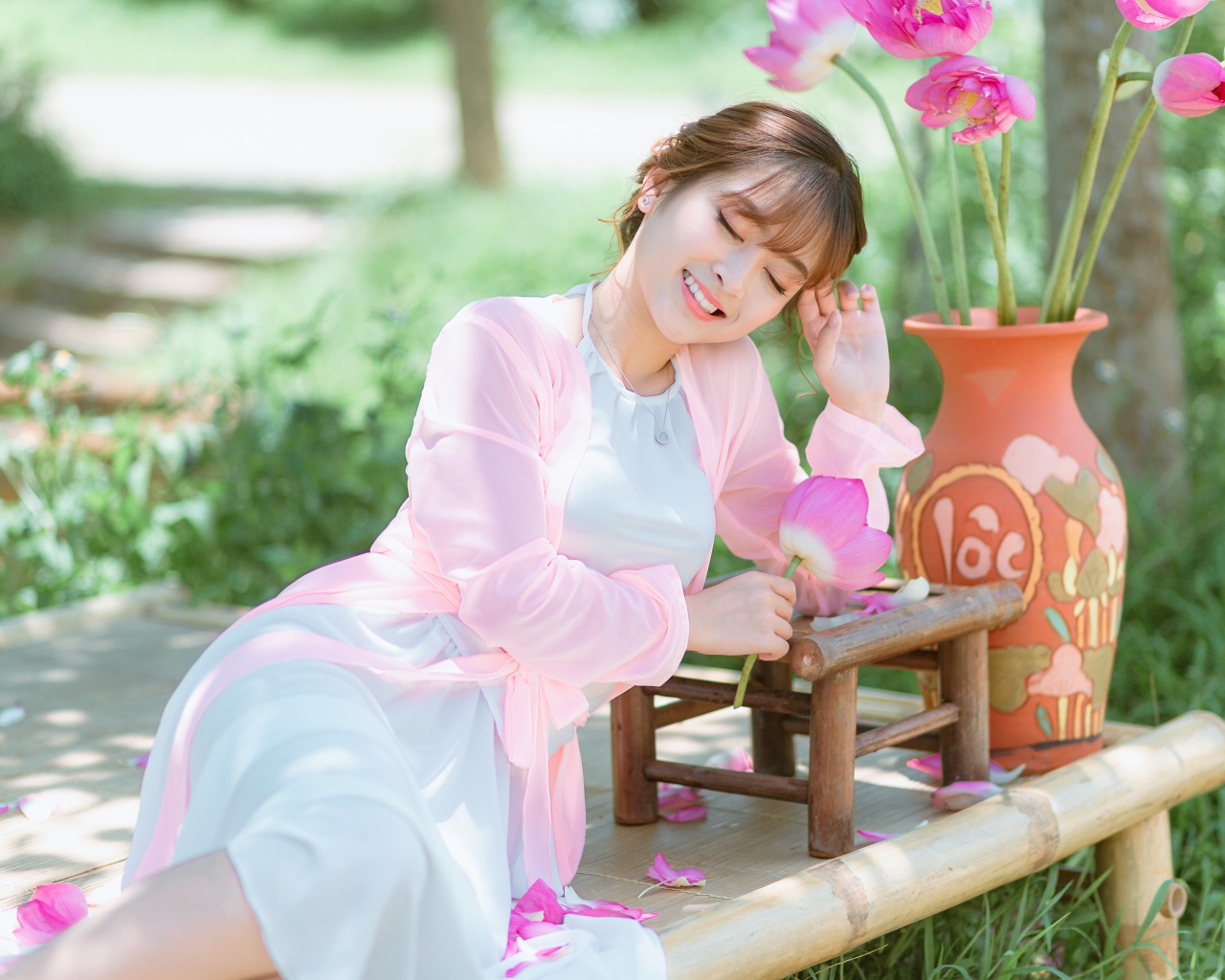 Мечтательная девушка азиатка с цветами лотоса