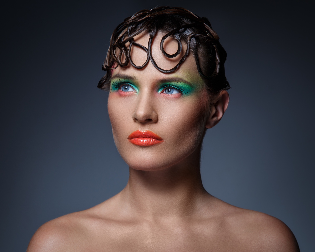 Девушка с ярким макияжем на сером фоне 
