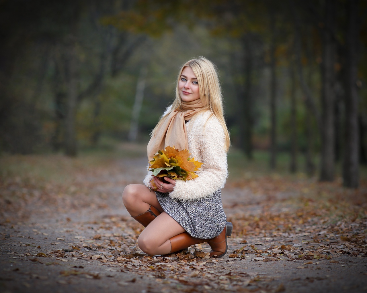 Девушка с листьями на дороге осенью