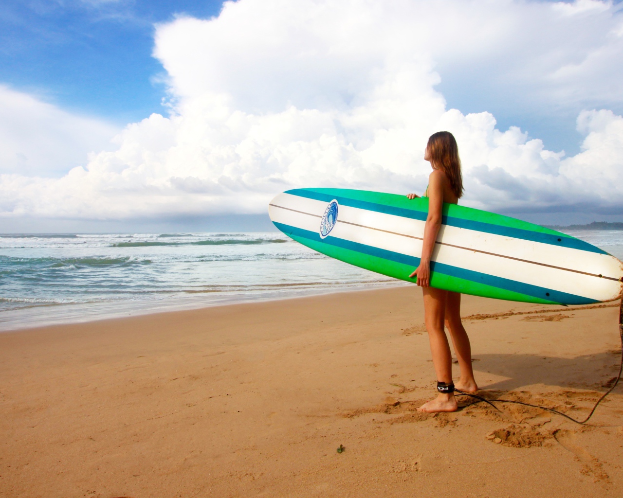 Девушка с доской для серфинга на пляже 