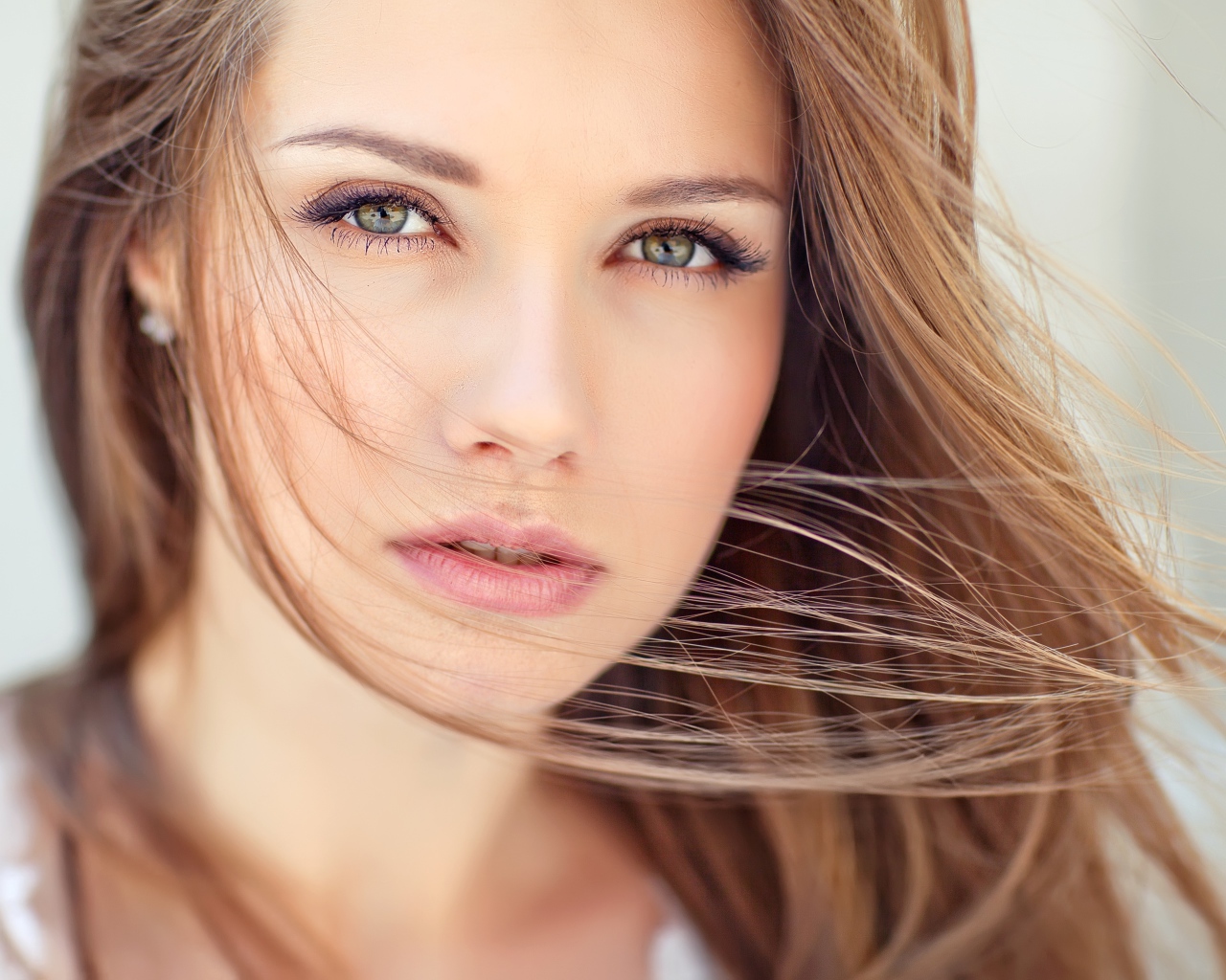 Волосы развеваются ветром на лице у девушки