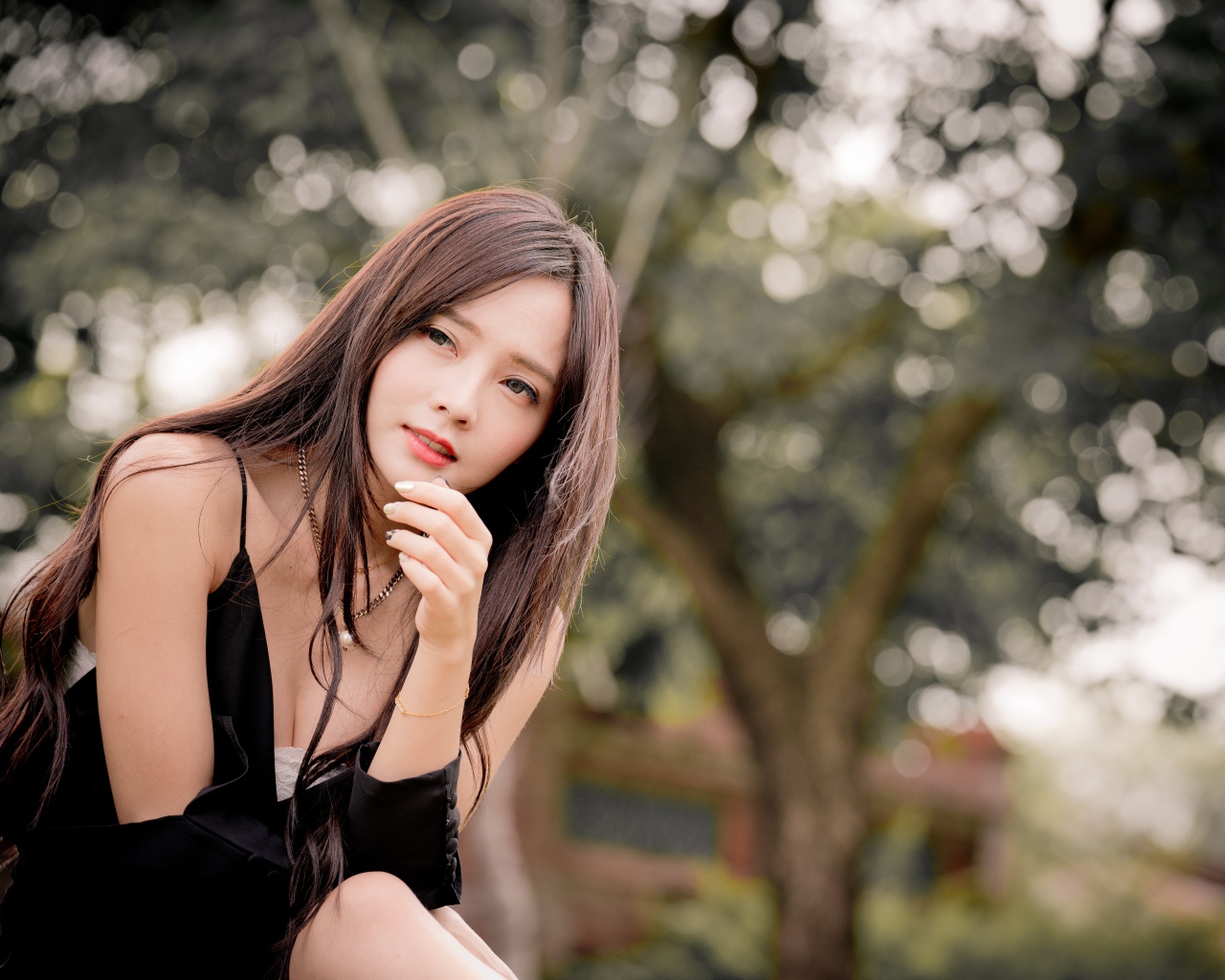 Задумчивая девушка азиатка в черном платье 