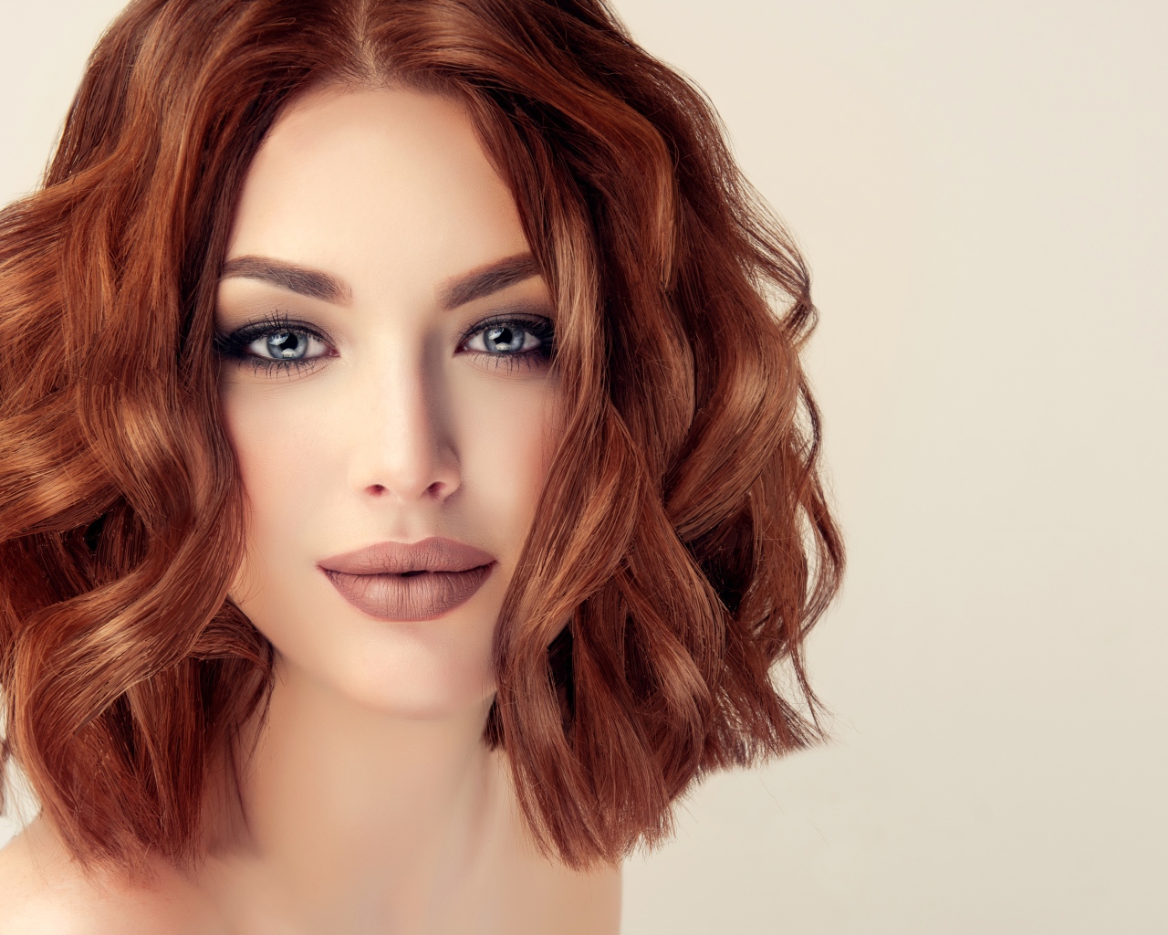 Рыжеволосая голубоглазая девушка на сером фоне